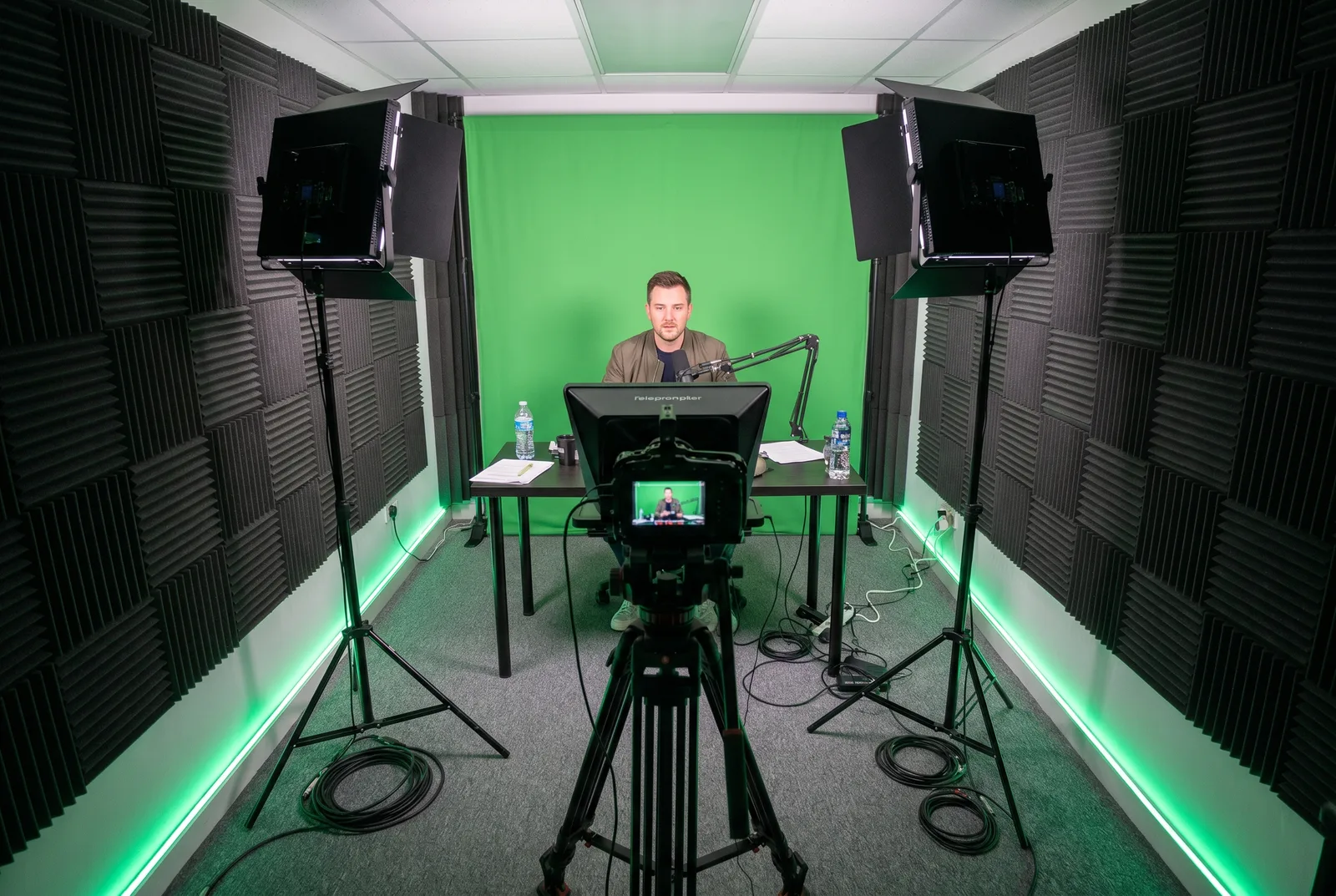 A presenter recording to camera in front of a green screen