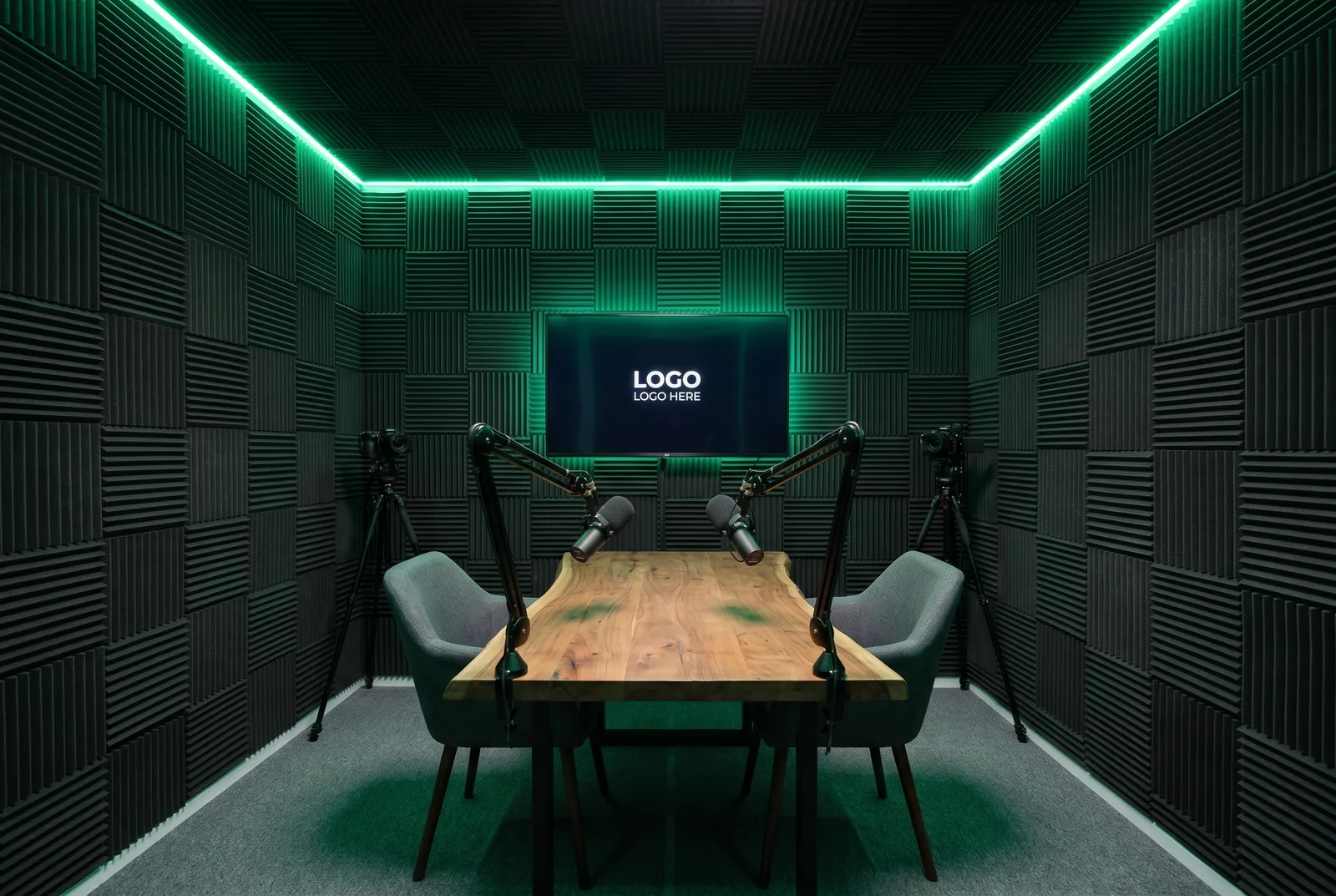 The studio set for an interview: two chairs facing each other across the table, two microphones on boom arms